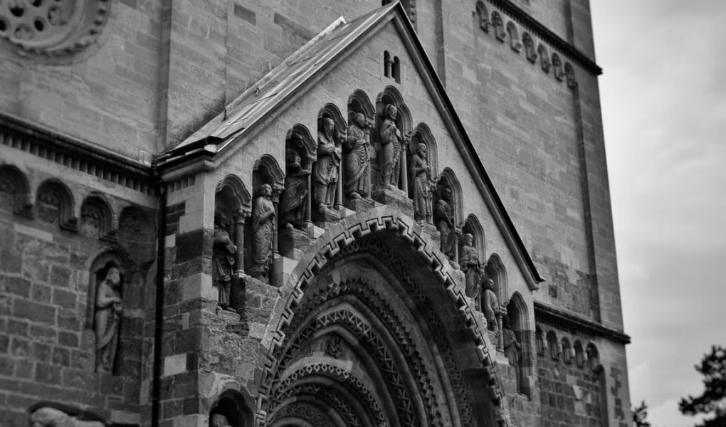 Vintage-style photograph capturing the intricate details of Ják Church's façade in Hungary.